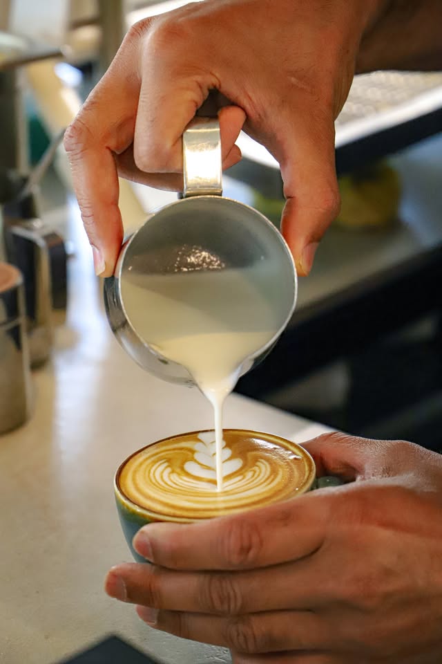 Milk being poured into a cup to finish the latte art