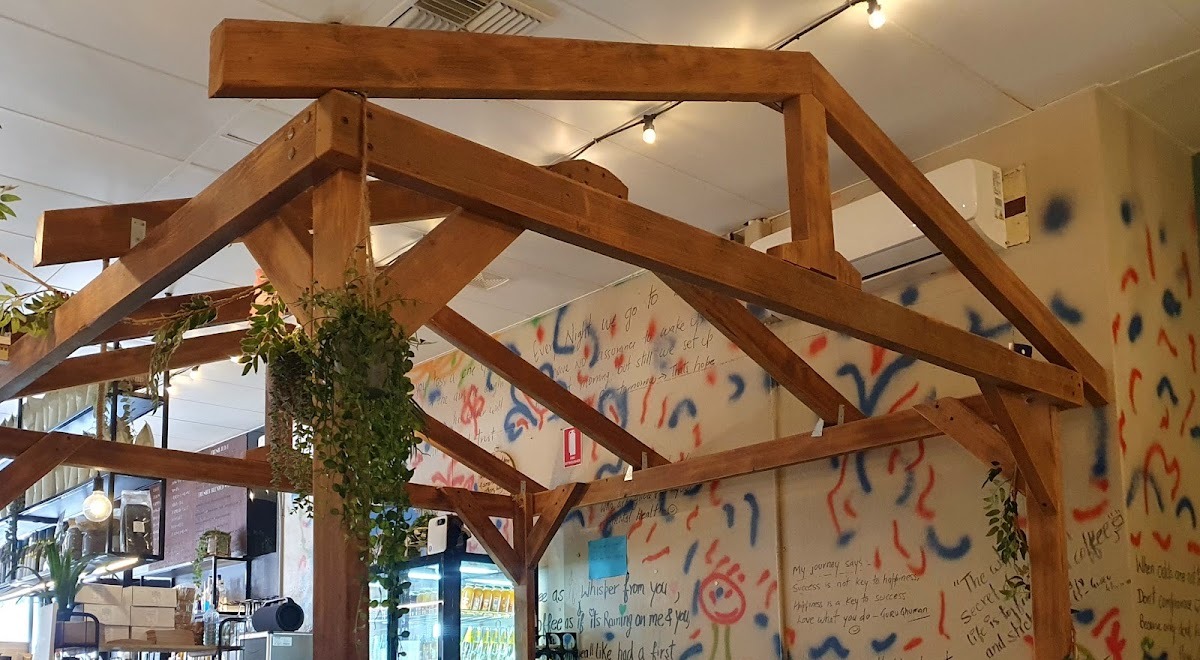Inside the cafe: exposed timber trusses, hanging plants and the handwritten quote wall